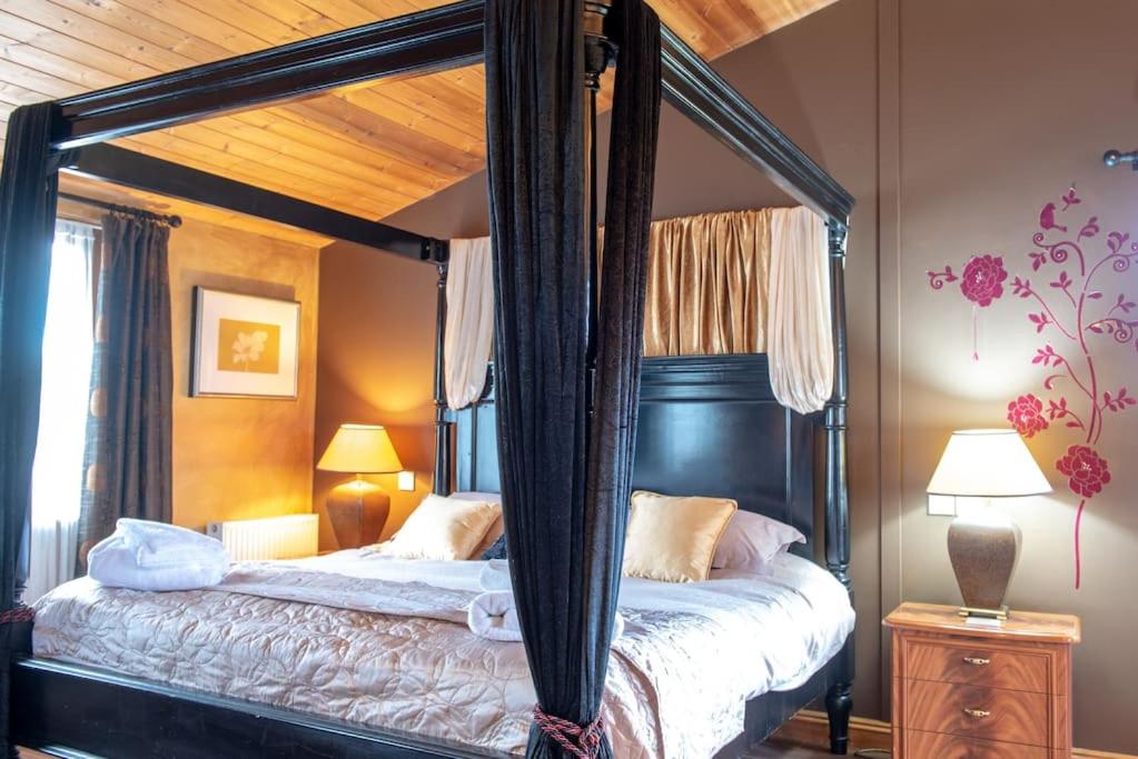 a bedroom with a four poster bed with a canopy at Havana Lodge - Still Rabbit - Hot Tub - Yorkshire in York
