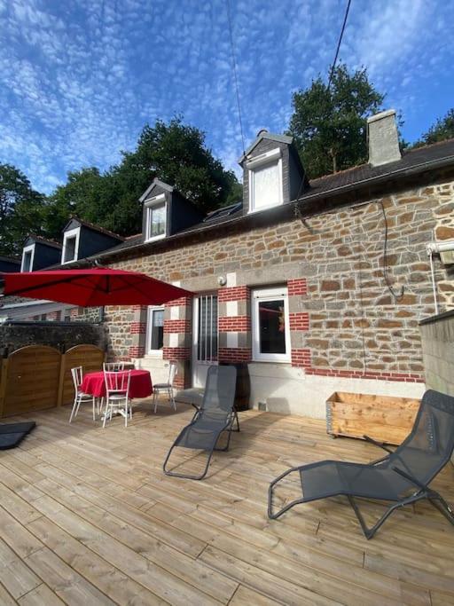 un patio avec une table et des chaises et un bâtiment en briques dans l'établissement Maison au bord de l'eau, à Saint-Brieuc