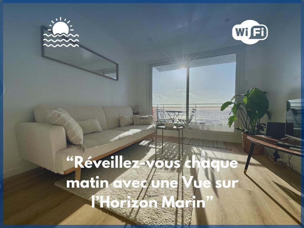 a living room with a couch and a large window at Azur à la Chaume in Les Sables-dʼOlonne