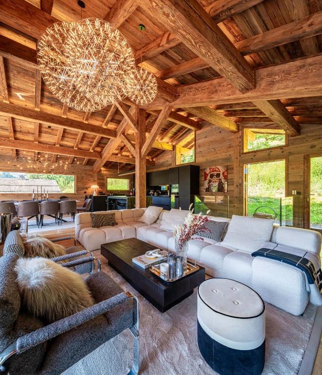 un grand salon avec un canapé et un lustre dans l'établissement Chalet TheMoon - La Clusaz, à La Clusaz