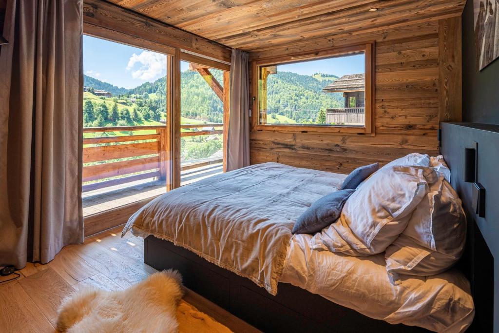 a bedroom with a bed in front of a large window at Chalet TheMoon - La Clusaz in La Clusaz