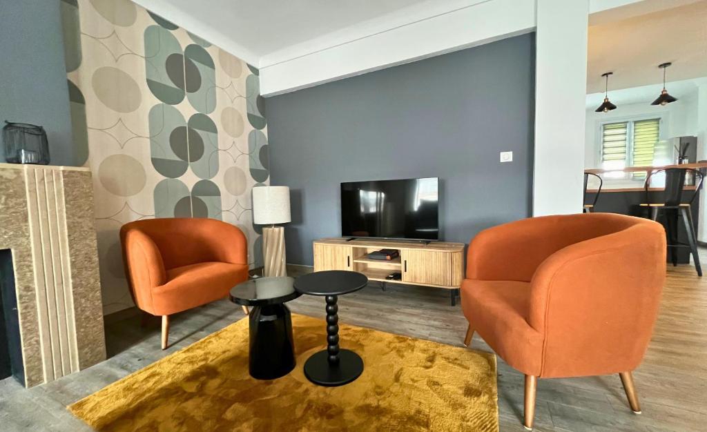 un salon avec deux chaises et une télévision dans l'établissement Appart 2 Chambres - 6 pers Standing Hyper Centre, à Boulogne-sur-Mer