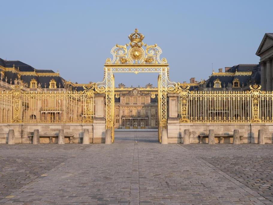 une grande porte dorée au milieu d'un bâtiment dans l'établissement Studette moderne, cosy et équipée en plein cœur de Versailles!, à Versailles