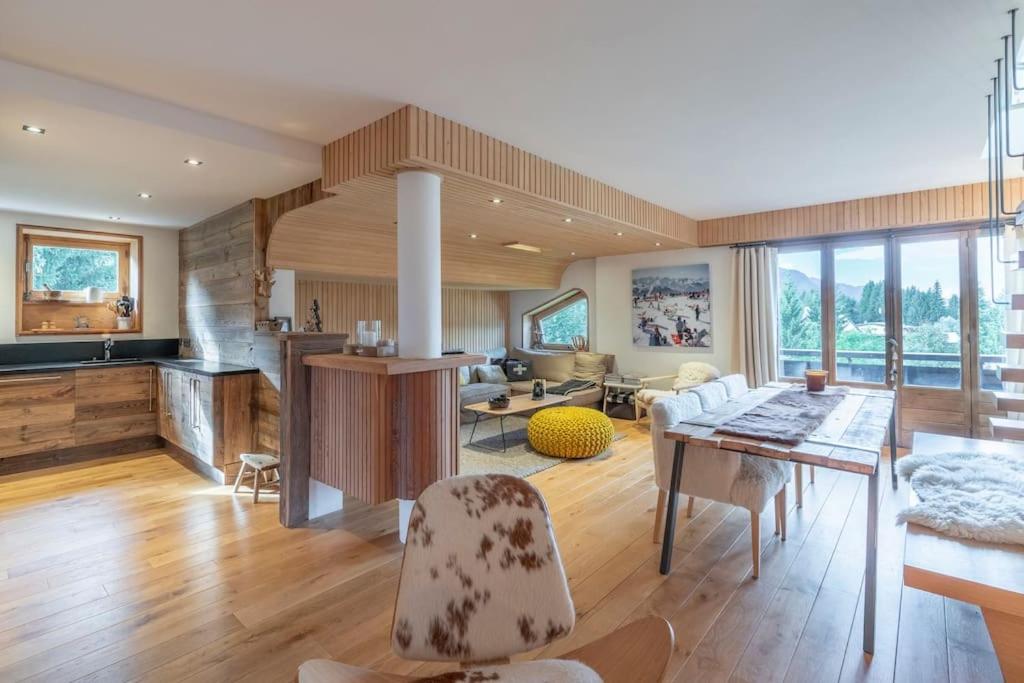 une cuisine et un salon avec une table et des chaises dans l'établissement Très bel appartement Duplex 9 couchages, à Megève