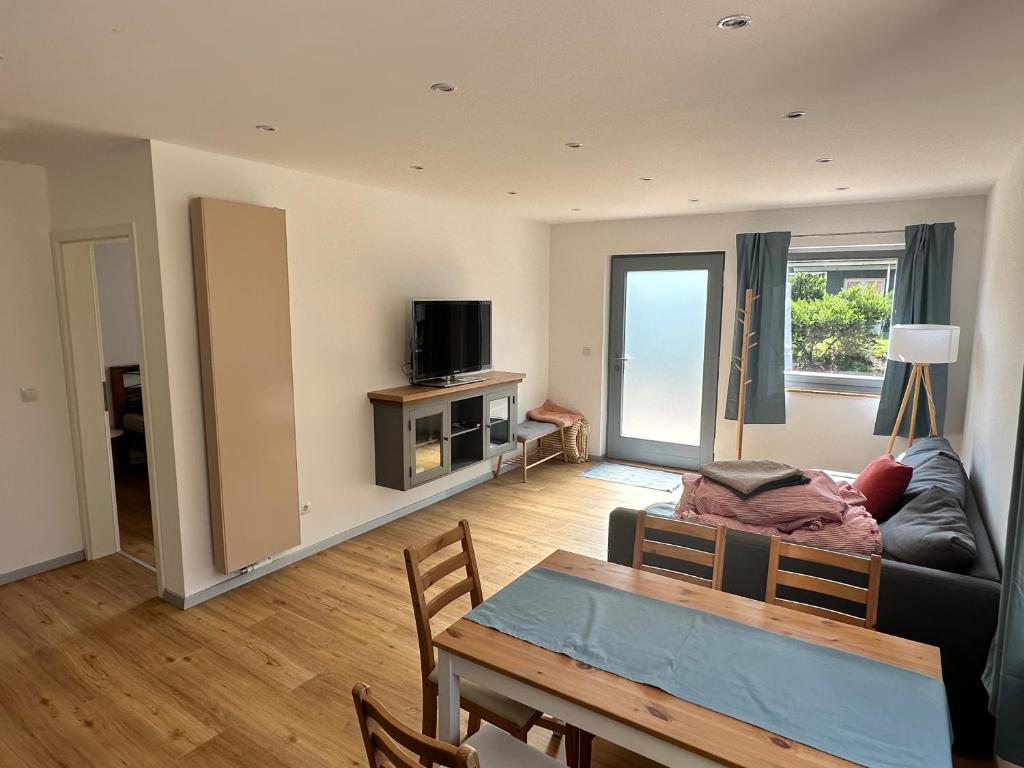 a living room with a table and a couch at Ferienwohnung am Kastanienbusch in Birkweiler