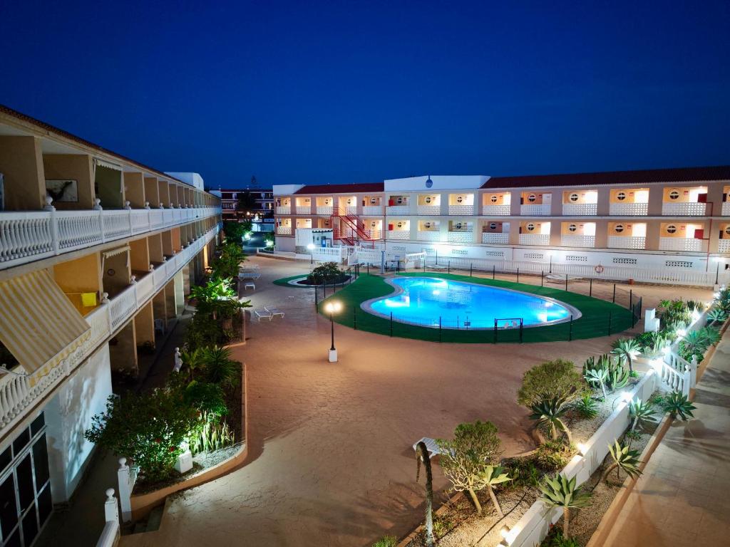 an apartment complex with a swimming pool at night at Encantador Estudio con Terraza Privada y Espectaculares Vistas al Mar en Costa del Silencio, Cerca de Los Cristianos in Costa Del Silencio