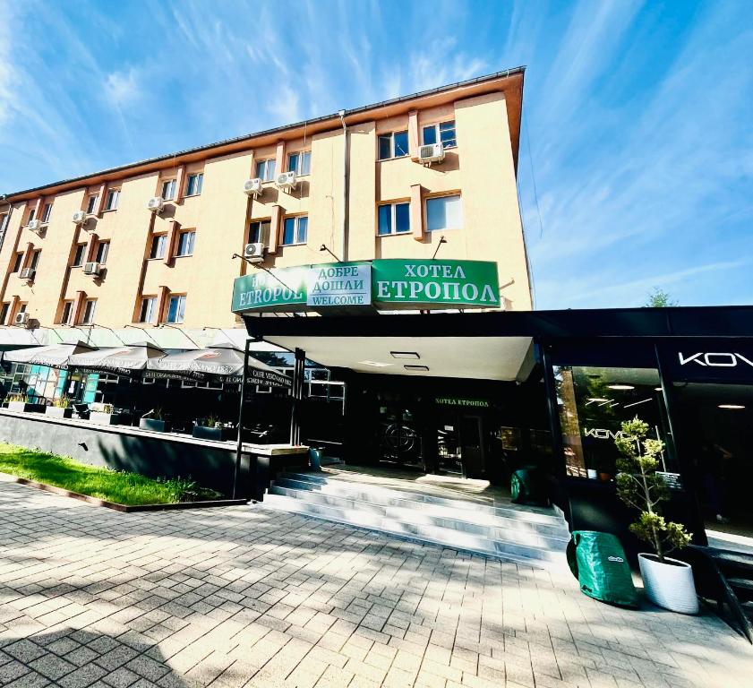 a hotel building with a sign on the front of it at Hotel Etropol Center Etropole in Etropole