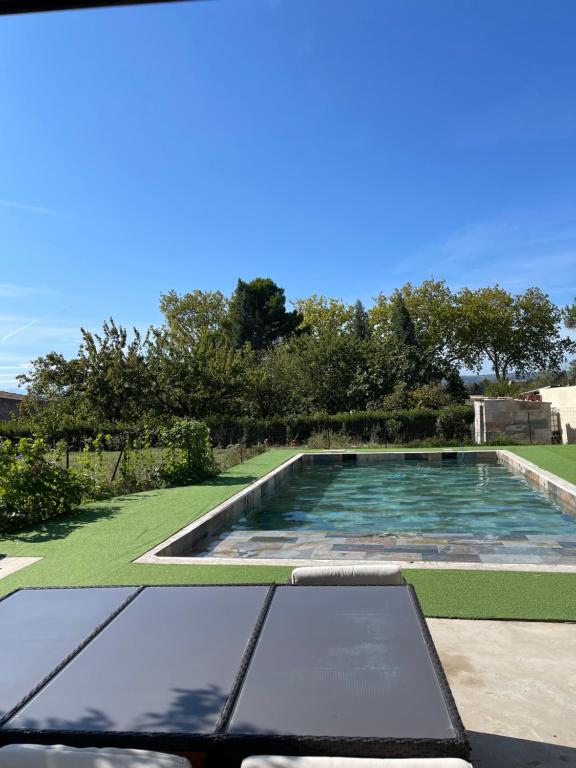 una piscina en un patio con árboles y césped en Bali, en Saint-Martin-Lalande