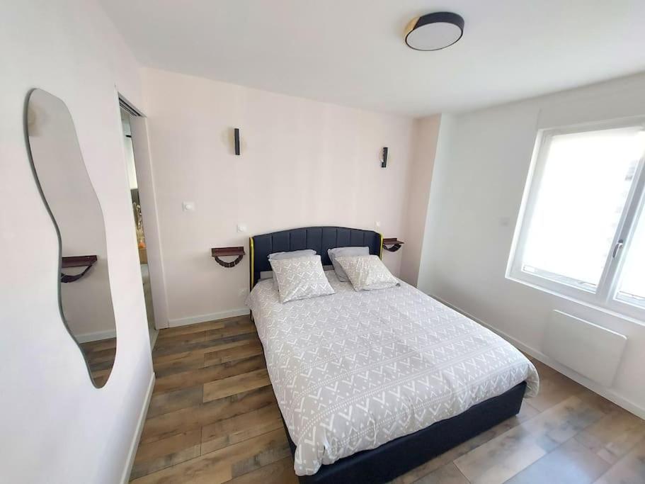 une chambre blanche avec un lit et une fenêtre dans l'établissement El bahia 2 , appartement centre-ville, à Boulogne-sur-Mer