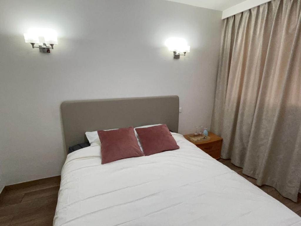 une chambre avec un lit blanc avec deux oreillers dessus dans l'établissement Paris chambre luxe -opéra 15mins-chambre avec salle de bain commune, à Paris