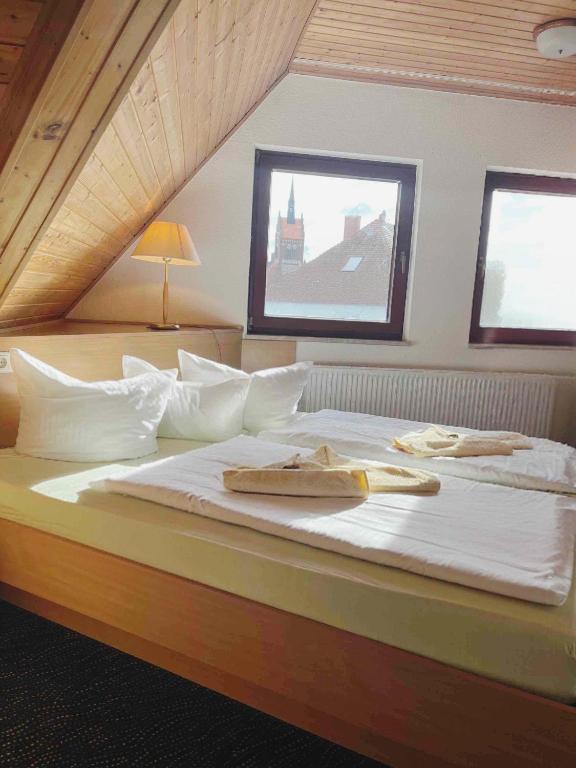 a large bed with white sheets and towels on it at Monteurzimmer Usedom in Usedom Town