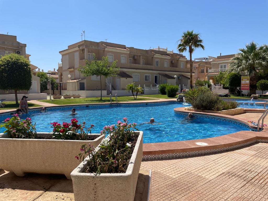 a swimming pool with people swimming in it at Lovely 2 bedroom apartment on El Divino, Los Alcazares in Los Alcázares