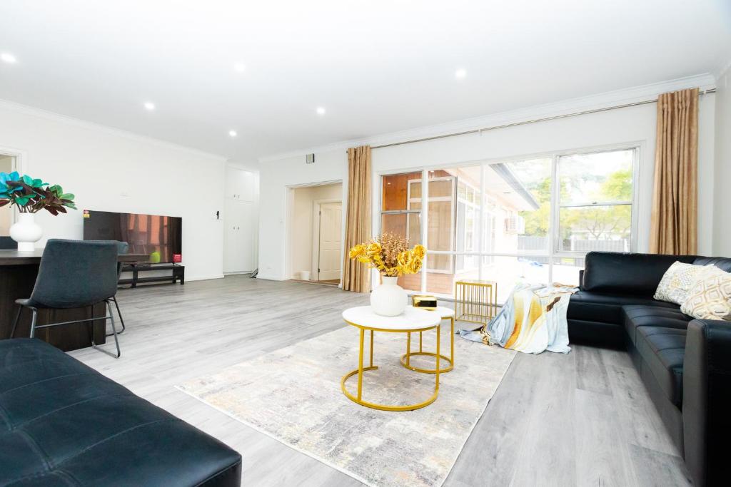 a living room with a couch and a table at Adelaide Escape and Business-3Bath Full Kitchen Fast Wifi 3TV-for large families and group in Glenunga