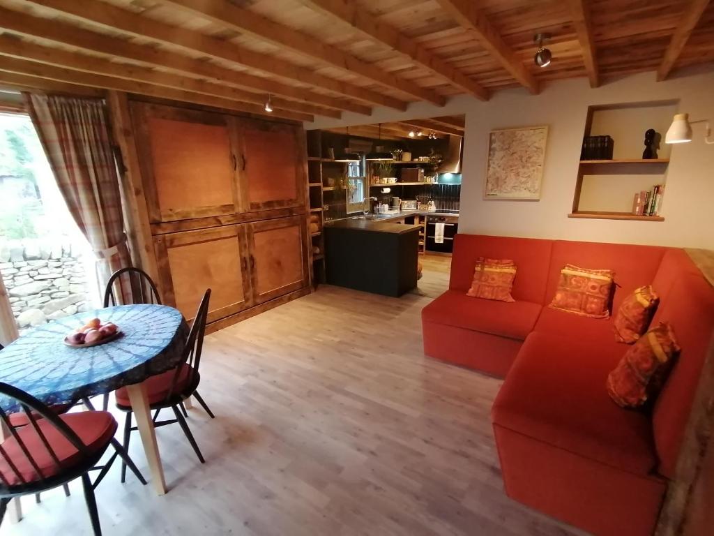 a living room with a red couch and a table at Stone Moor Lodge Justin's Peak District Base Camp in Sheffield