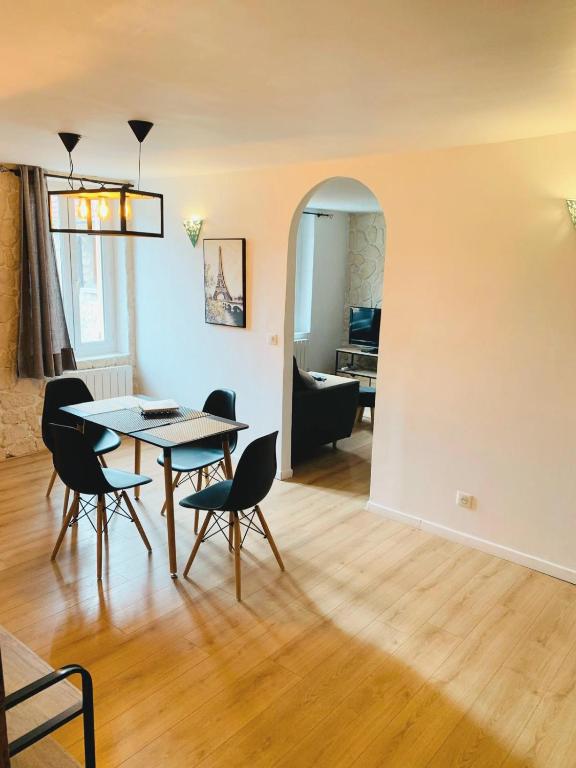 une salle à manger et un salon avec une table et des chaises dans l'établissement La perle rare Chambly, Proche Parc Astérix , château de Chantilly, à Chambly