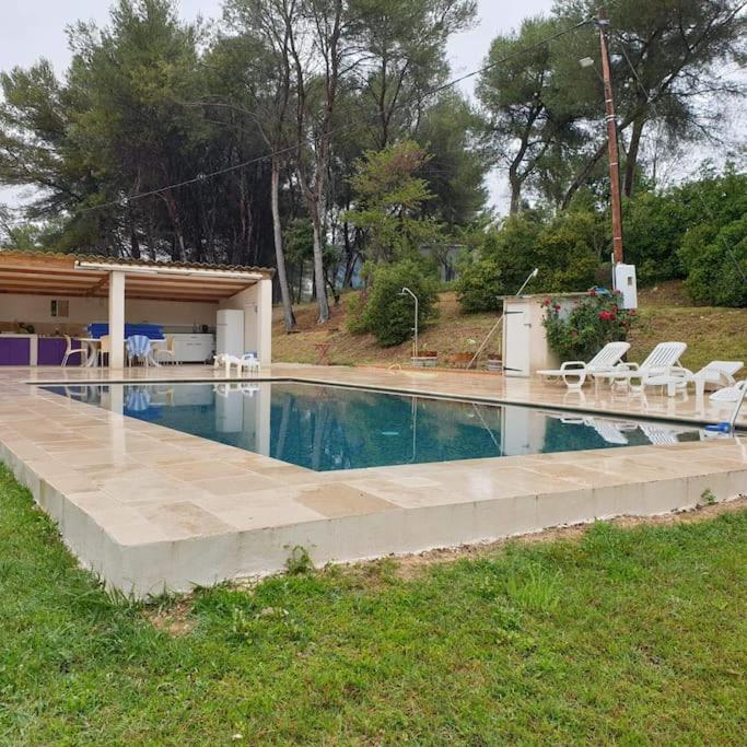 une grande piscine avec des chaises et une maison dans l'établissement Appartement dans campagne aixoise, à Ventabren