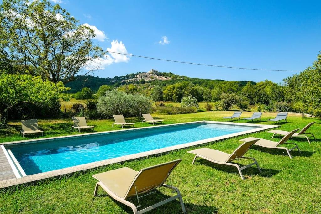 a pool with chaise lounge chairs and a bunch at 4 stars farmhouse, heated pool, view, 15 people in Bonnieux