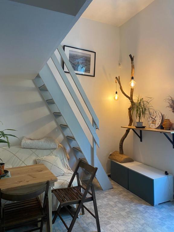 Cette chambre dispose d'un escalier avec une table et une chaise. dans l'établissement Appartement cosy proche Tour Eiffel, à Paris
