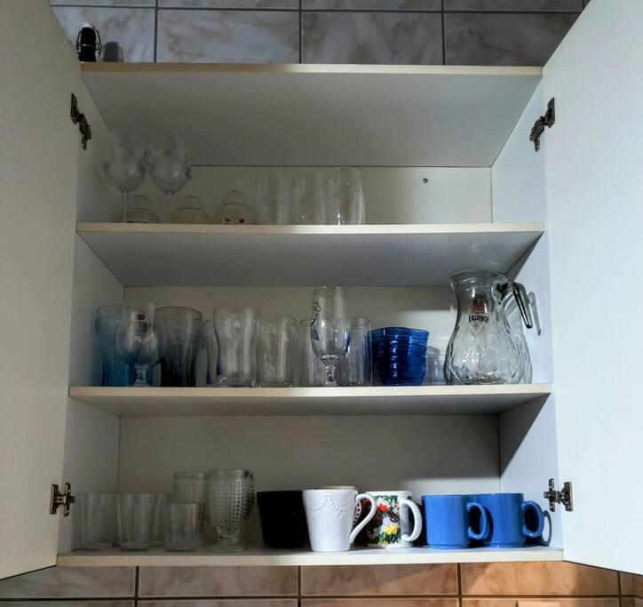 a shelf filled with glass vases and mugs at Casa para família in Itatiba