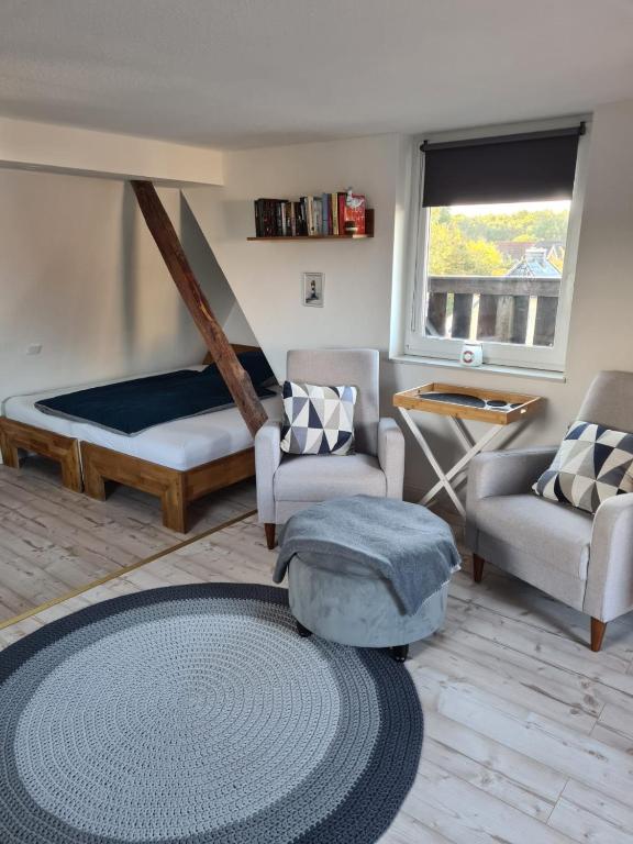 a living room with a bed and chairs and a rug at Ferienwohnung Schnelzer in Sahlenburg