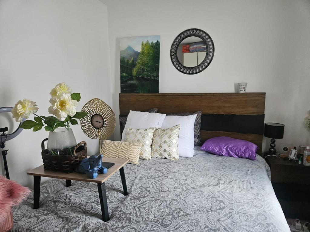 a bedroom with a bed with a table and flowers at De Pearl Home Tatu City - Nairobi in Nairobi