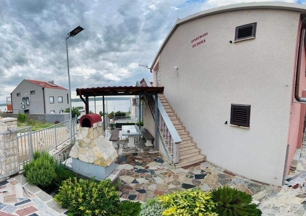 a building with a staircase on the side of it at Apartmani Budiša Maslenica in Maslenica