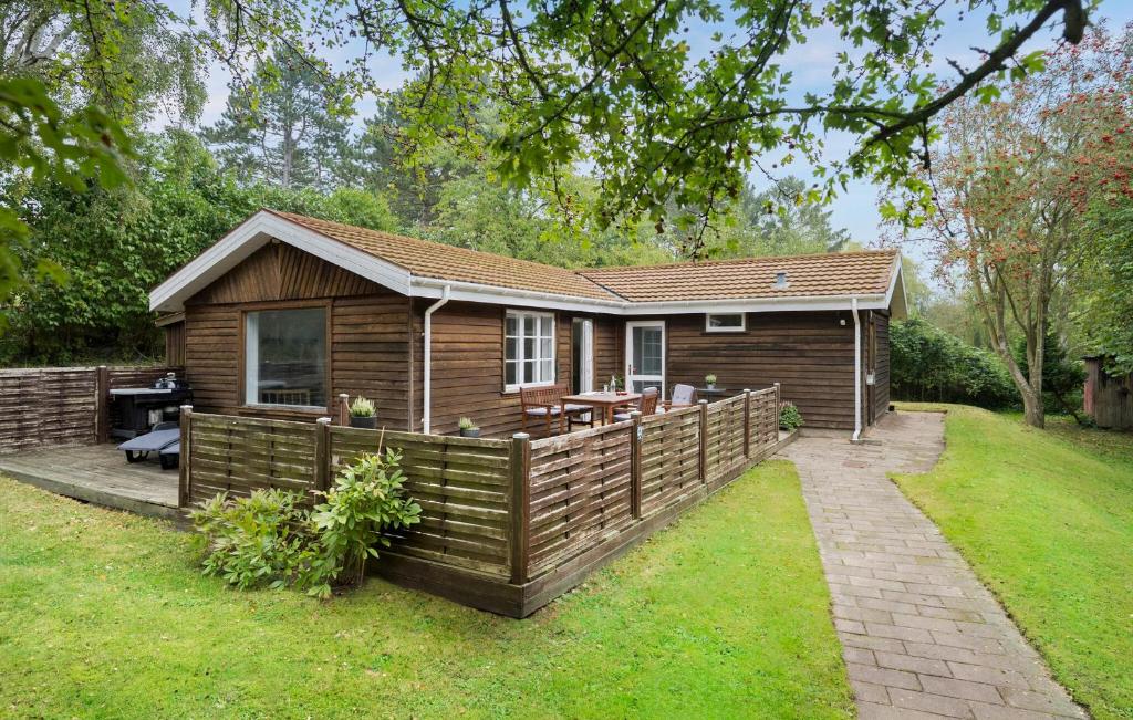 a small cabin with a wooden fence in the yard at Awesome Home In Korsør With Wifi in Korsør