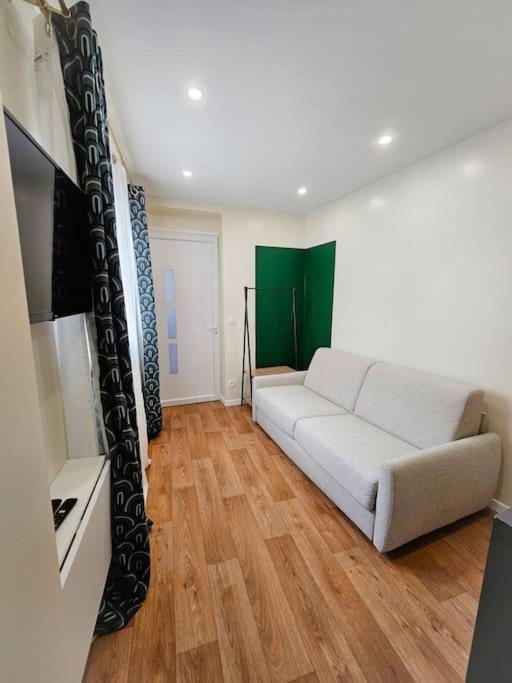 un salon avec un canapé blanc et une télévision dans l'établissement Studio Moderne et confortable au coeur de Cambrai, à Cambrai