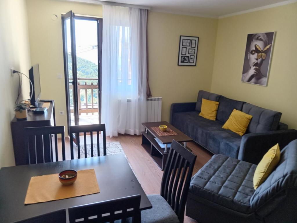 ein Wohnzimmer mit Sofa und Tisch in der Unterkunft Sunny Days apartman Kopaonik in Kopaonik