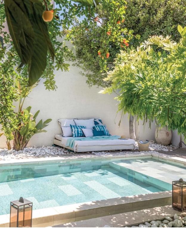 un lit assis à côté d'une piscine avec des arbres dans l'établissement Casa Grande Motte, à La Grande Motte