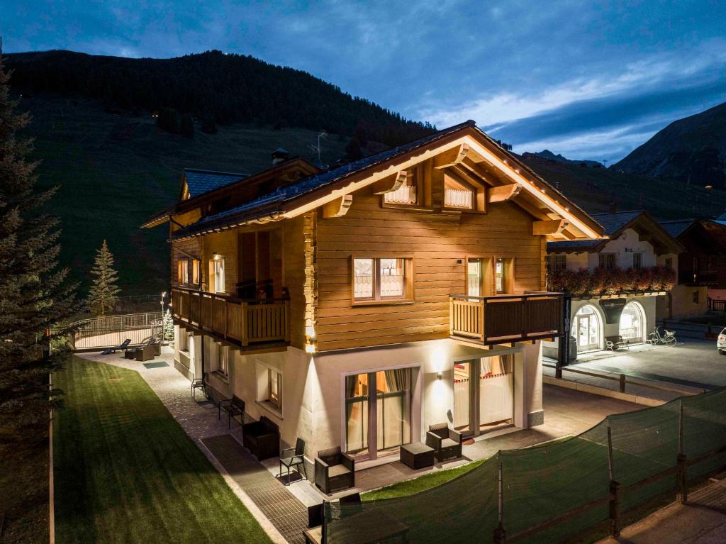 duży drewniany dom z werandą i balkonem w obiekcie AG Apartments Livigno centro w Livigno