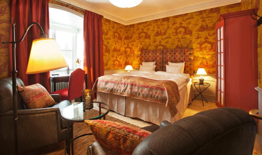 une chambre d'hôtel avec un lit et un canapé dans l'établissement Rosersbergs Slottshotell, à Rosersberg