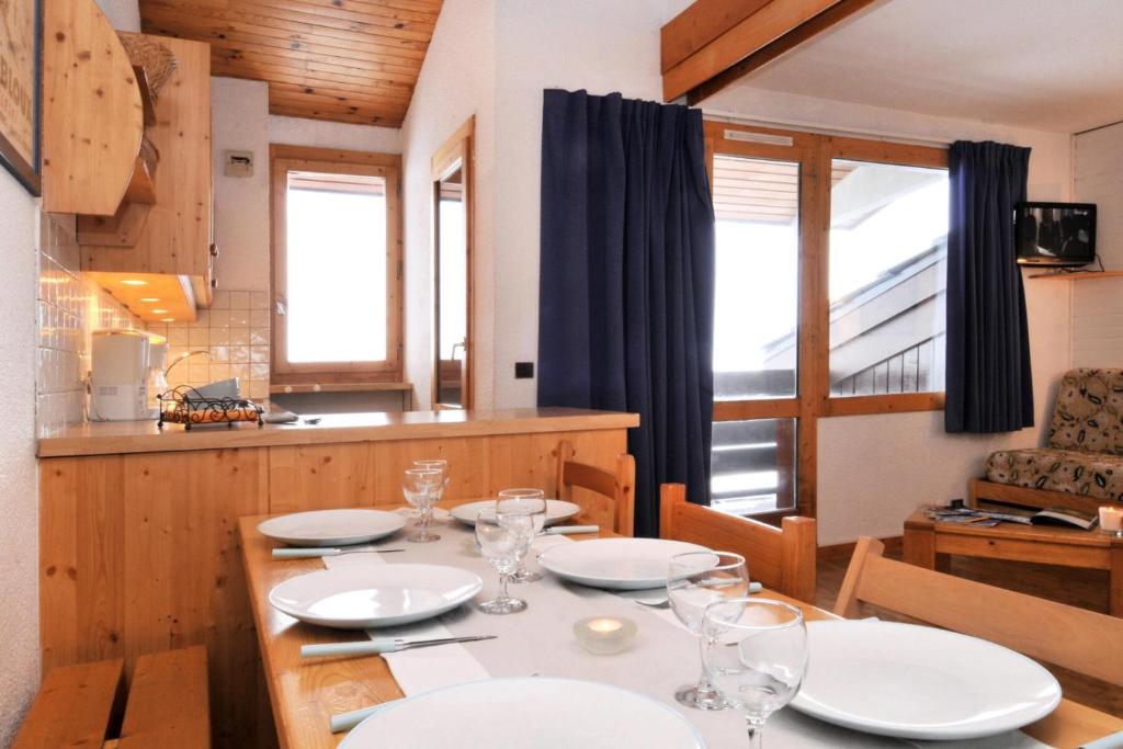 une salle à manger avec une table, des assiettes et des verres dans l'établissement Résidence Agate - 3 Pièces pour 7 Personnes 54, à Mâcot La Plagne