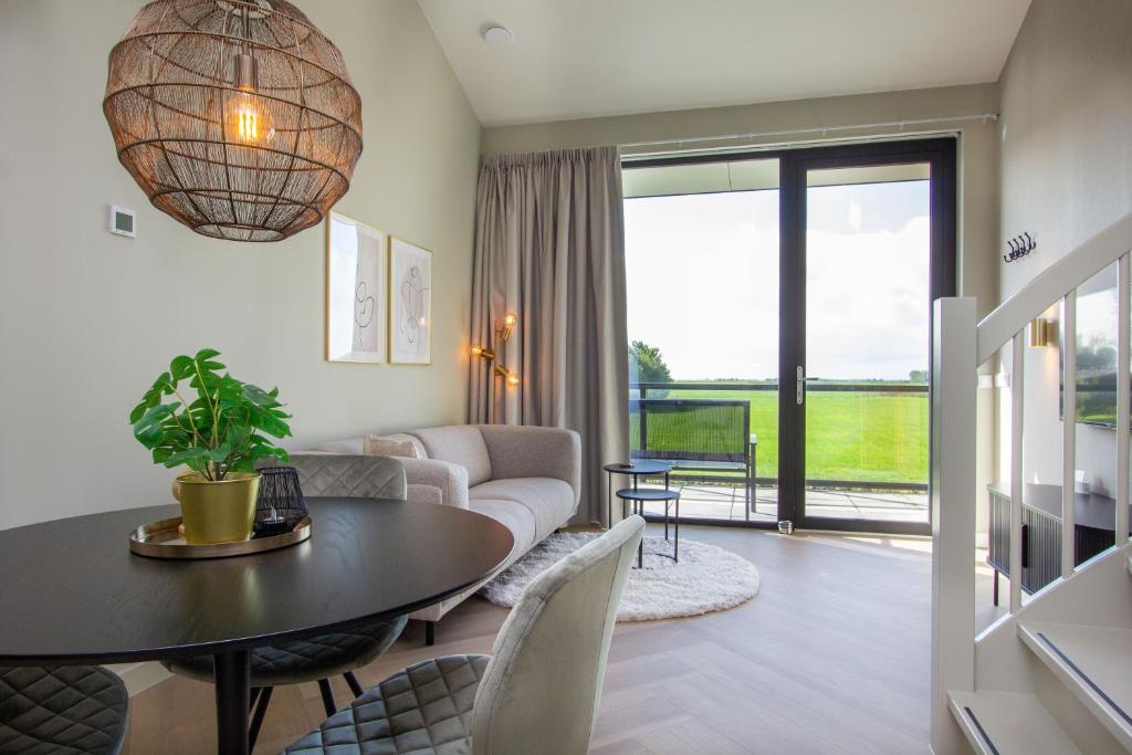 a living room with a table and a couch at Wolkom Thús in Itens