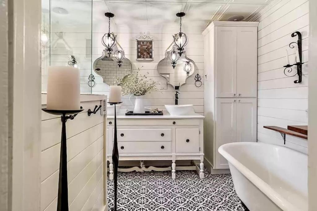 a white bathroom with a tub and a sink at 1930s Queen Anne Historic Downtown Retreat in Medford