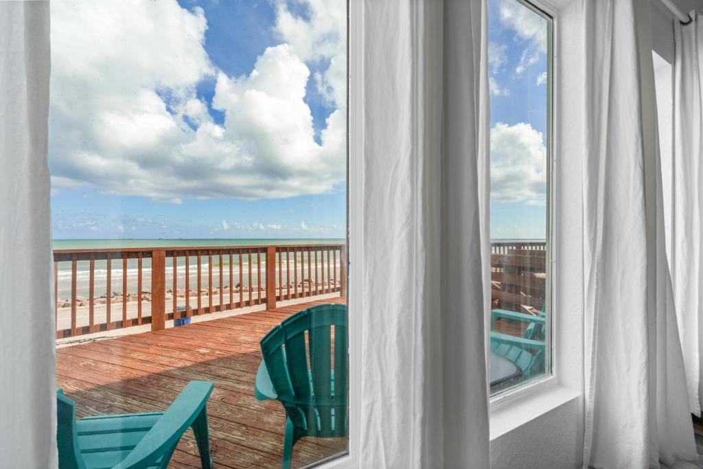 a balcony with chairs and a view of the ocean at Amazing Oceanfront 2BR Home Cozy Peaceful and Kid and Pet Friendly in Freeport