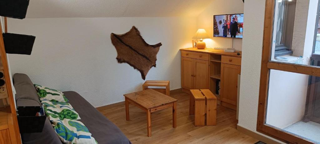 une chambre avec un lit et une table dans une pièce dans l'établissement Studio calme pour 4 ou 6 personnes, skis aux pieds, aux Menuires