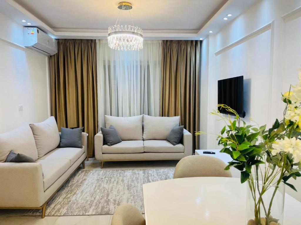 MadinatyProperty Sisters, Elite new home, Madinaty B11的客厅配有2张白色沙发和吊灯。