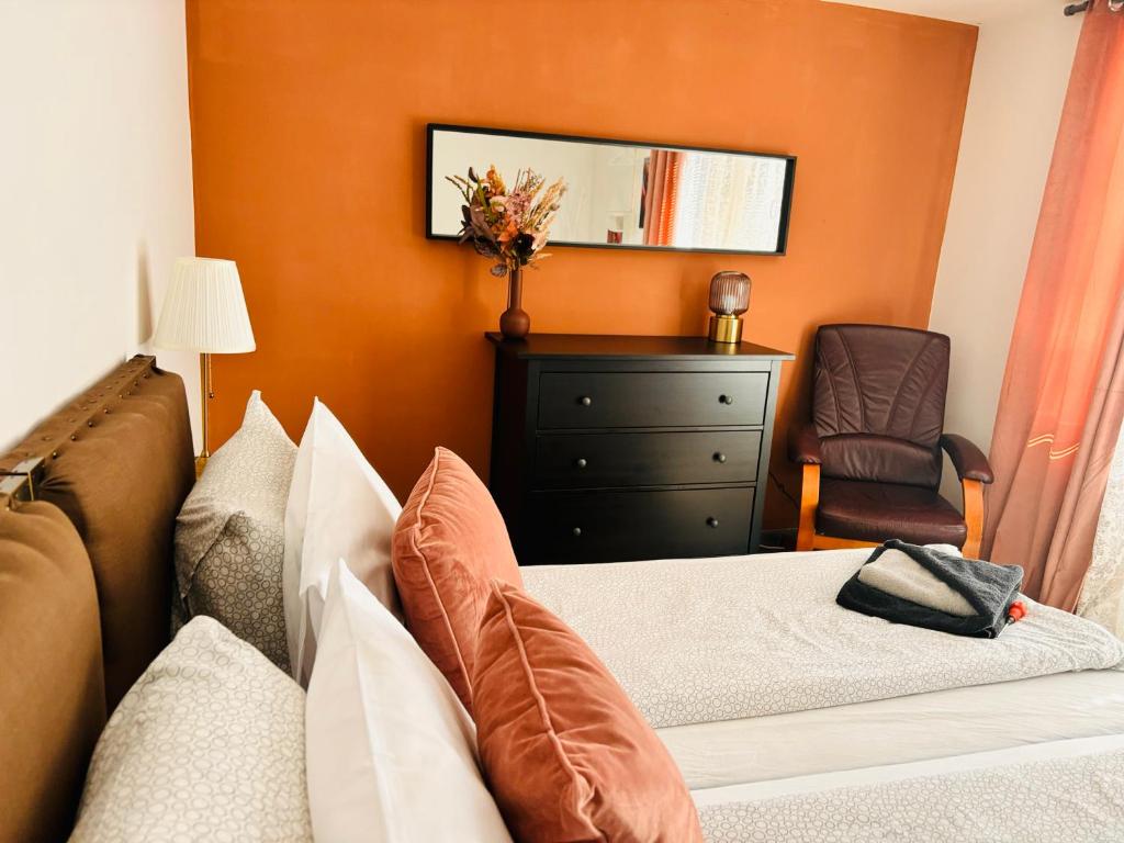 a bedroom with a bed and a dresser and a chair at Guest House Malusha in Gabrovo