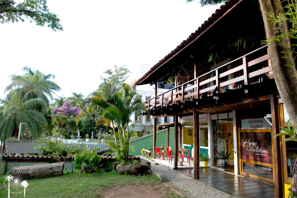 a resort with a building with a porch and trees at Da Orla Pampulha Hostel in Belo Horizonte