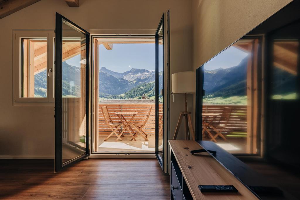 ein Zimmer mit großem Fenster und Blick auf die Berge in der Unterkunft Chuenislodge2- zwei Balkone, gemütlicher Kamin, top Aussicht in Adelboden