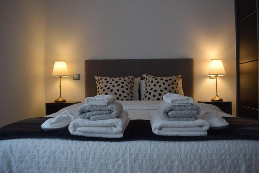 a bed with white towels stacked on top of it at Inmejorable Apartamento cerca Estación Delicias con GARAJE in Zaragoza