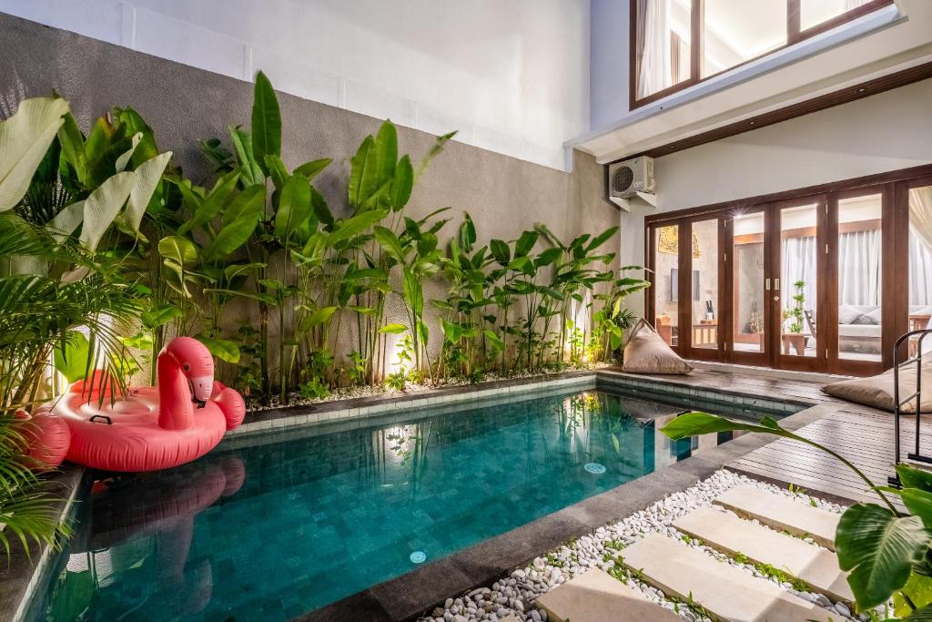 ヌサドゥアにあるTaman Dharmawangsa Villa - 3BR Luxury Private Pool Villa in Nusa Duaのヴィラにある赤い白鳥のいる屋内プール