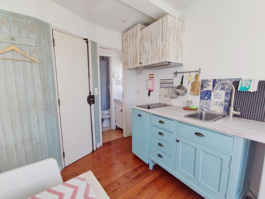 a kitchen with a blue cabinet and a sink at Cozy flat with marvelous view in Lisbon