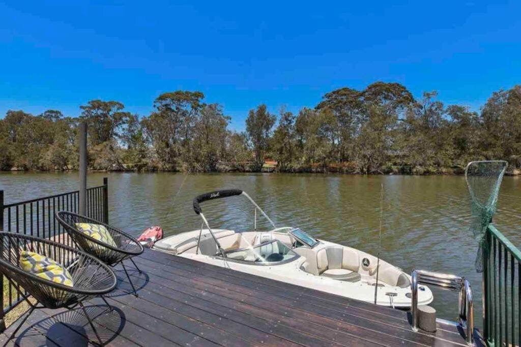een kleine boot geparkeerd op een steiger op een meer bij DOCK 08 Riverside Entertainer Pets Welcome in Chittaway Point