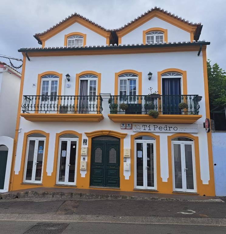 an orange and white building with a balcony at Apartment in Biscoitos Terceira in Biscoitos