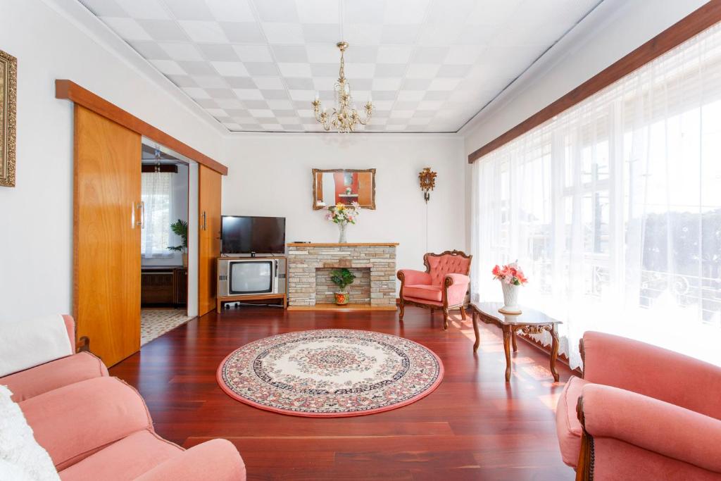 a living room with red chairs and a fireplace at Villa Fiore in South Fremantle