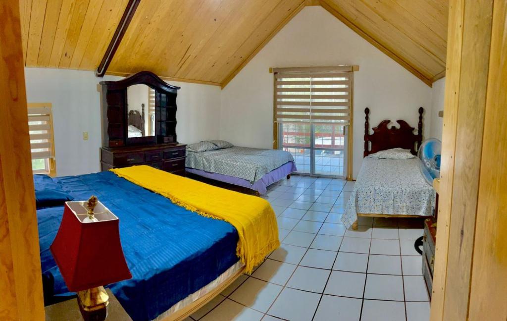 a bedroom with two beds and a mirror at Encantadora Cabaña de Campo con Alberca Privada in Chihuahua
