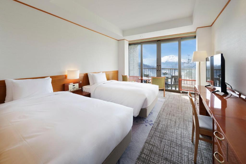 Postel nebo postele na pokoji v ubytování Karuizawa Asama Prince Hotel