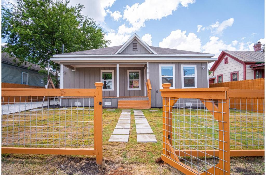 ein Haus mit einem Zaun vor einem Haus in der Unterkunft Seize the Moment 4BR3BA Gem w Downtown Views in San Antonio